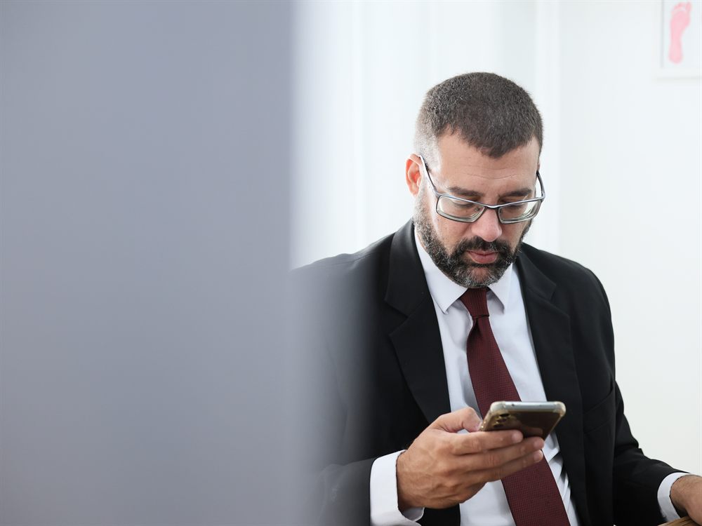 Advogado lendo uma mensagem no celular