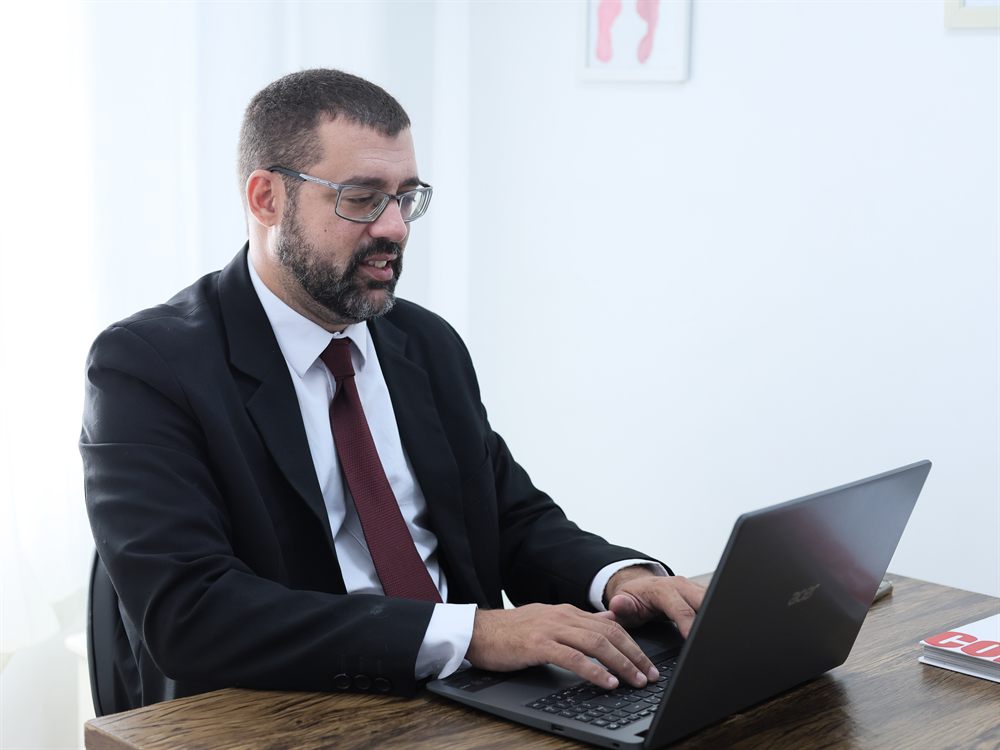 Advogado analisando documento no computador do escritório