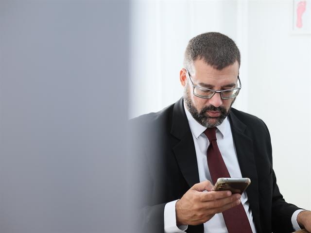Advogado lendo uma mensagem no celular
